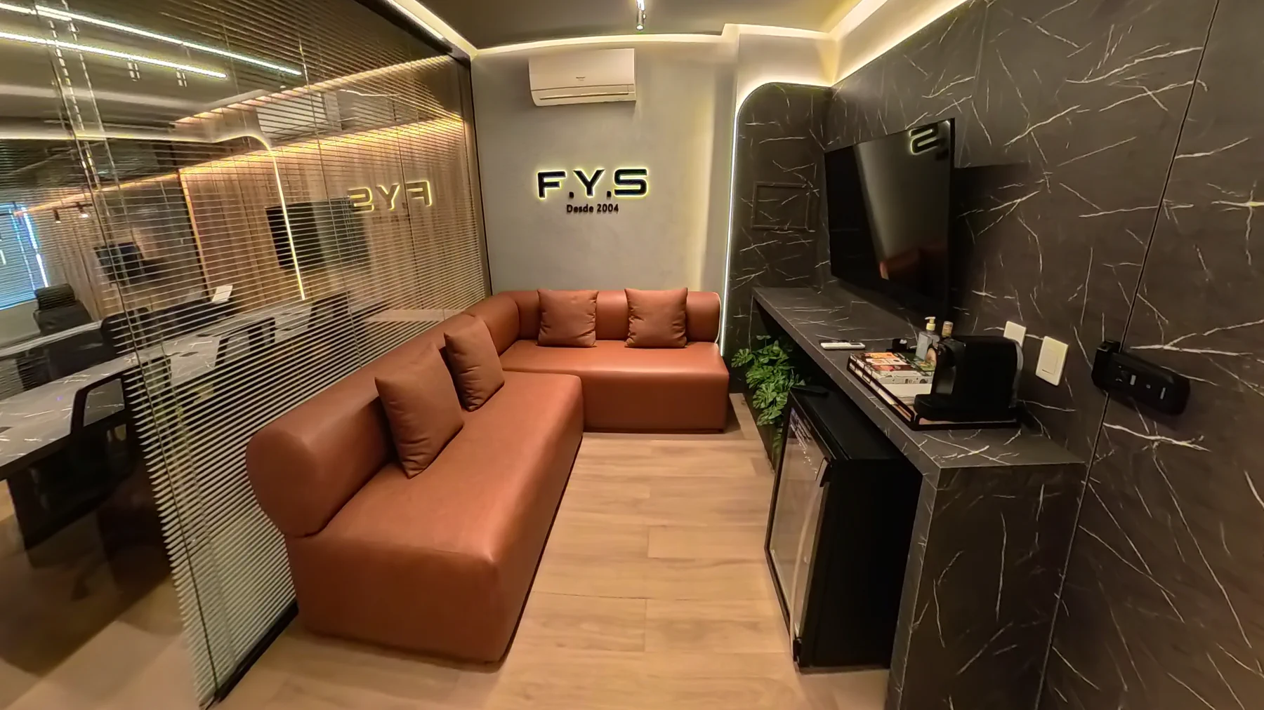 Recepção da F.Y.S com sofá e balcão de atendimento