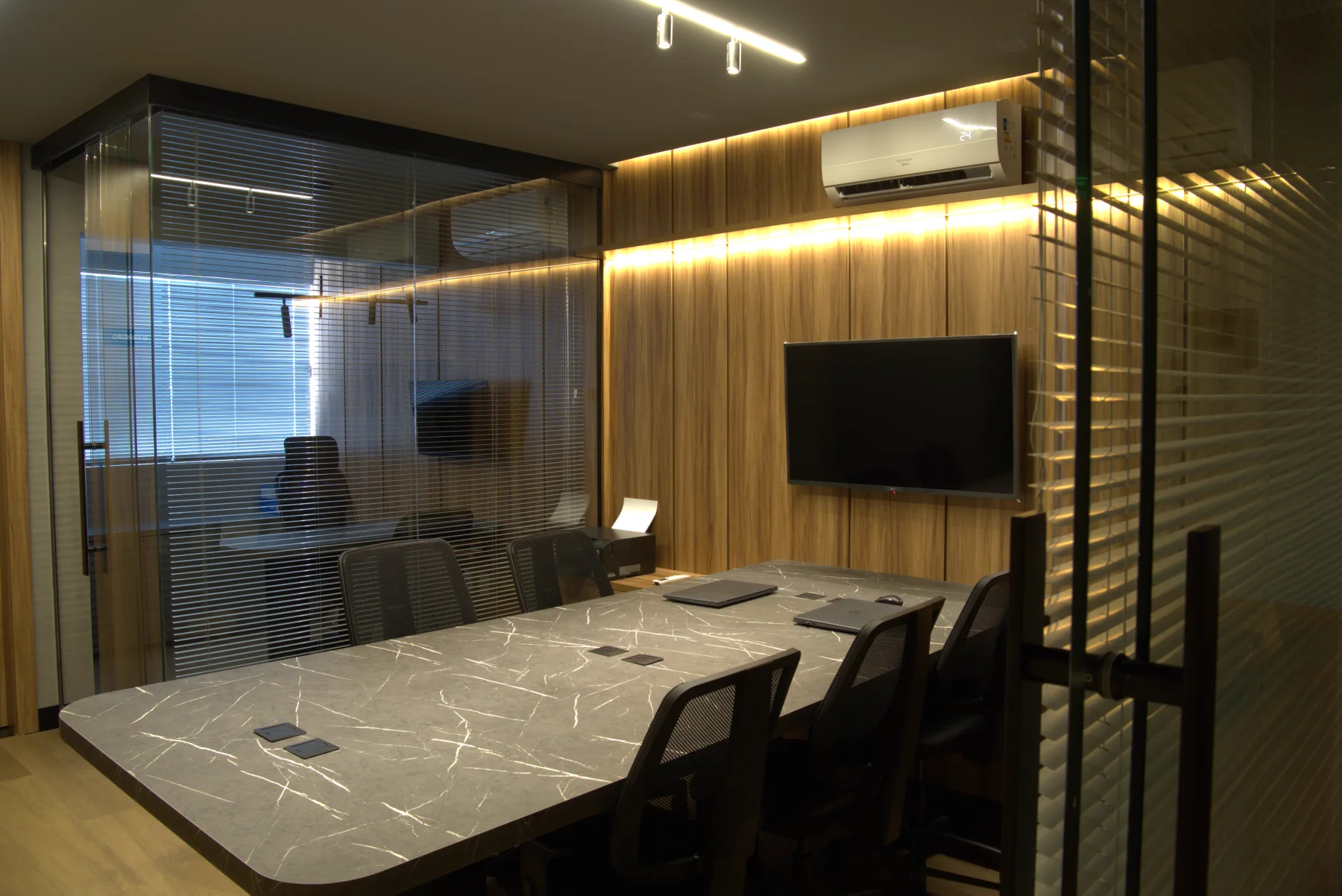 Sala de reunião da F.Y.S vista pela divisória de vidro