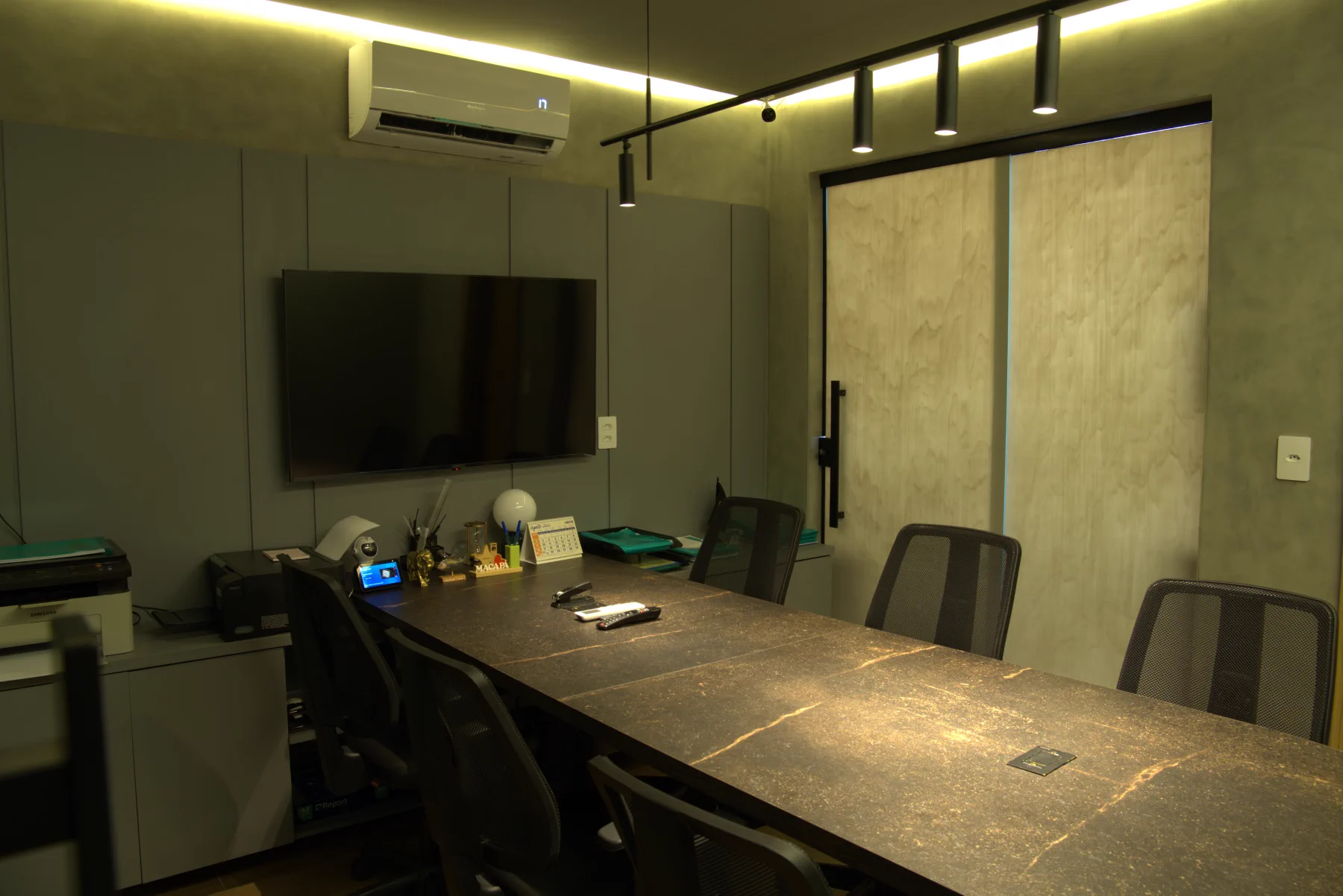 Ambiente de trabalho da F.Y.S com mesa e televisão