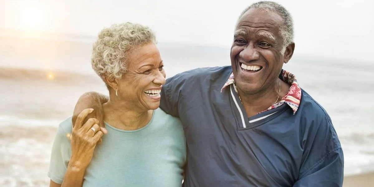 Casal sorrindo à beira-mar durante a aposentadoria